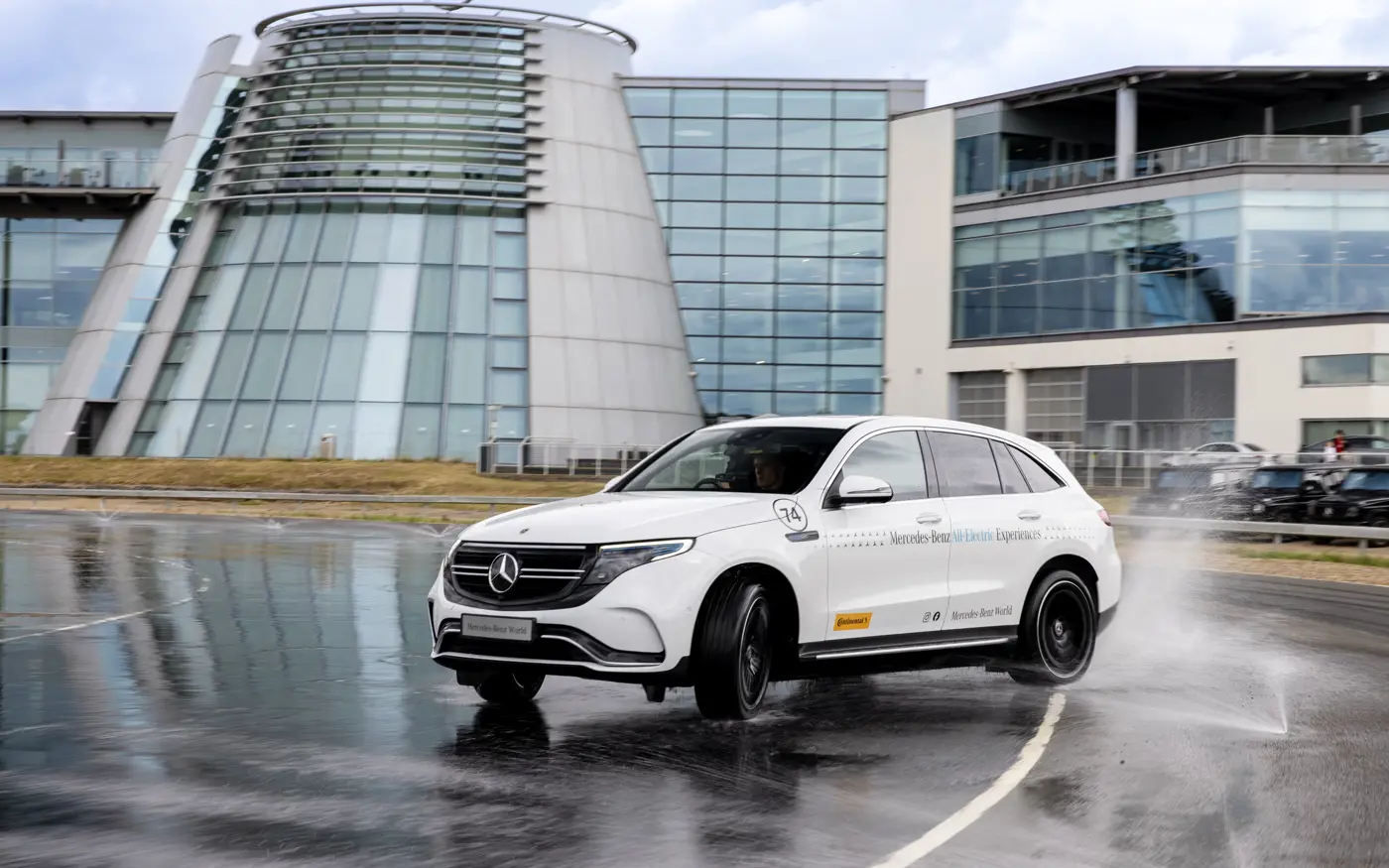 A young driver confidently handling a dual-controlled Mercedes-Benz on a dedicated training track at Mercedes-Benz World.