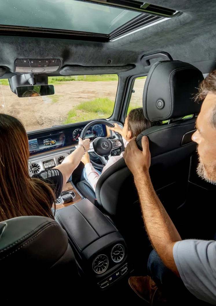 Young driver navigating a 4x4 vehicle over rugged terrain at Mercedes-Benz World's off-road course during a one-hour session.