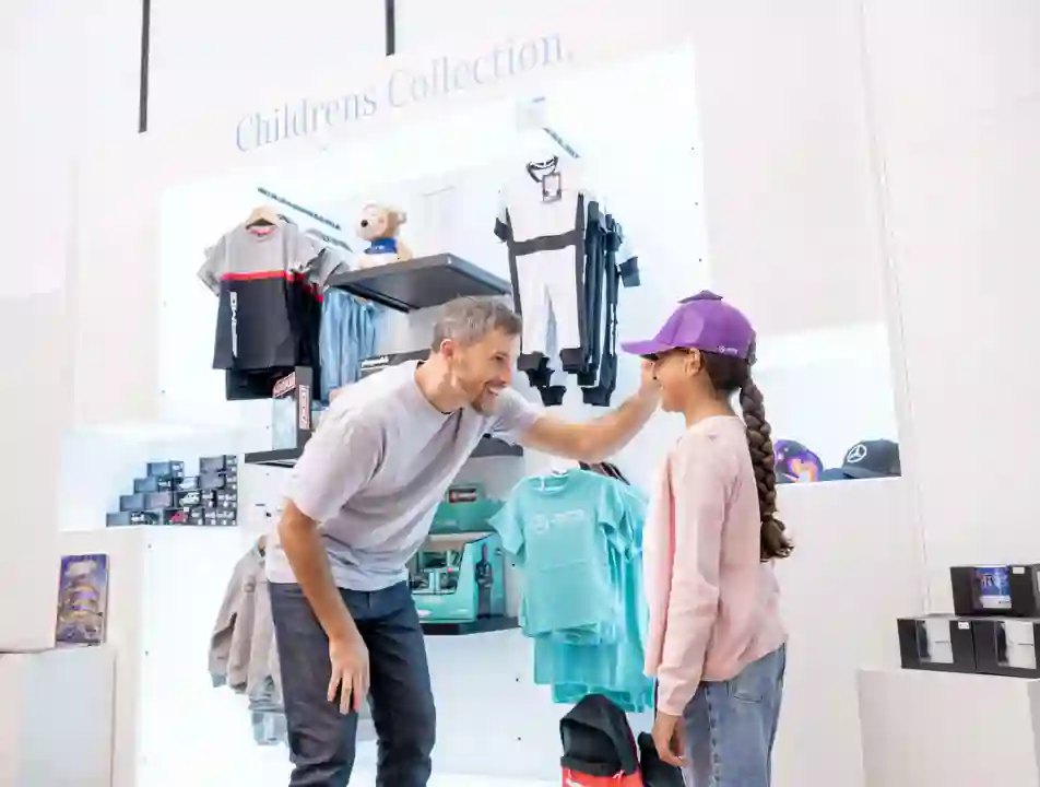 Interior view of the Mercedes-Benz World shop featuring branded merchandise, apparel, and automotive accessories.