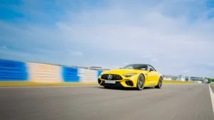 A Mercedes-Benz vehicle splashing through a water obstacle on the Off-Road Circuit, demonstrating 4MATIC traction and rugged capability.