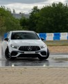 Mercedes-AMG car skidding through water on a track, demonstrating handling and control during a performance driving experience.