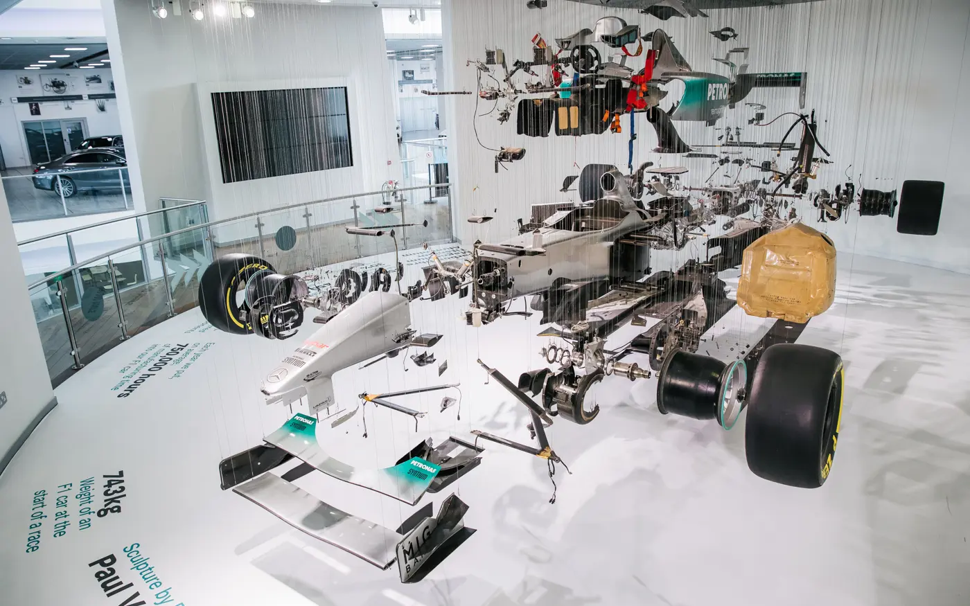 Suspended exploded-view display of a Mercedes-AMG Formula 1 car at Mercedes-Benz World, revealing detailed internal components and race engineering.