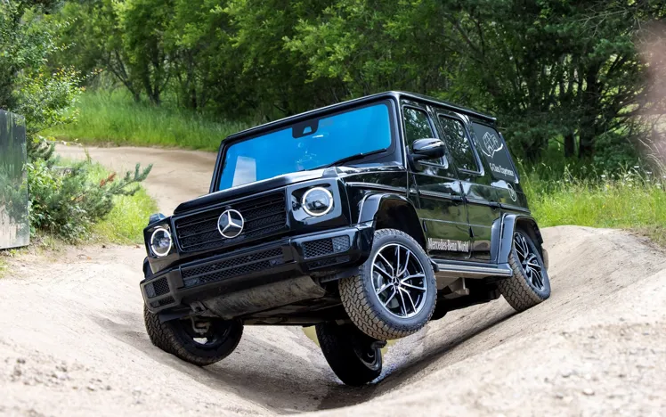 Mercedes-Benz SUV navigating a steep incline on the Off-Road Circuit at Mercedes-Benz World, demonstrating its advanced 4MATIC all-wheel drive system.
